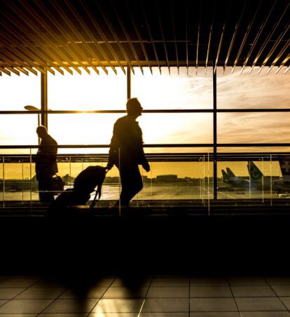 people walking through an airport with luggage